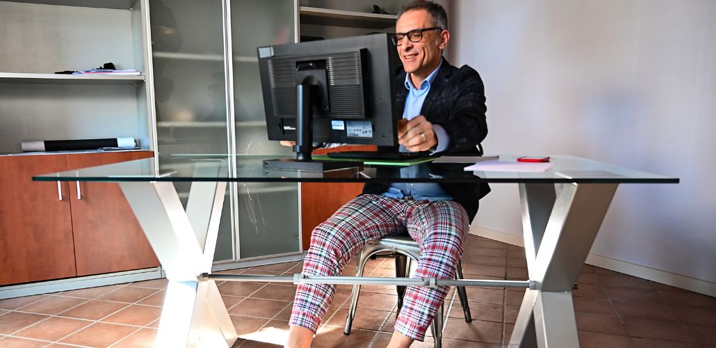 persona in smart con giacca e pigiama